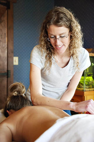 Abby Meyers using her forearm to massage a client's back